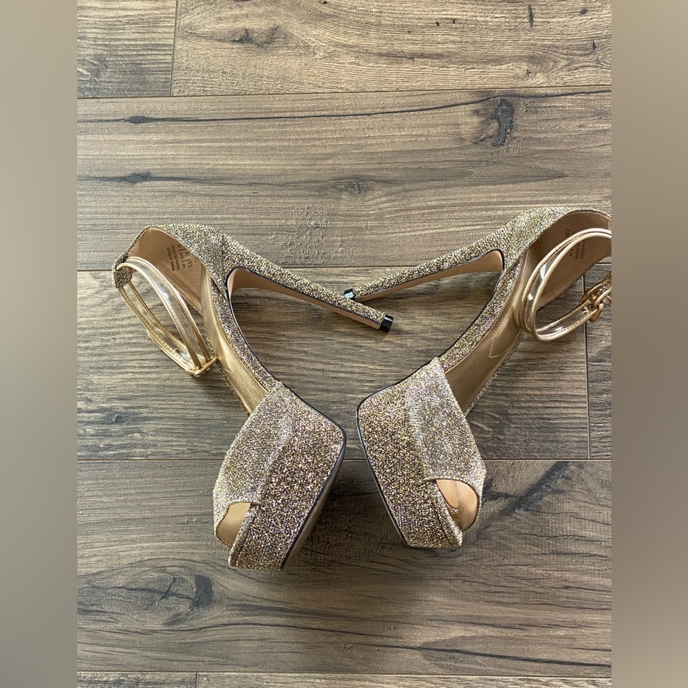 Aldo gold metallic platforms with clear ankle straps with gold trim.